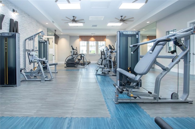 gym with ceiling fan and a skylight