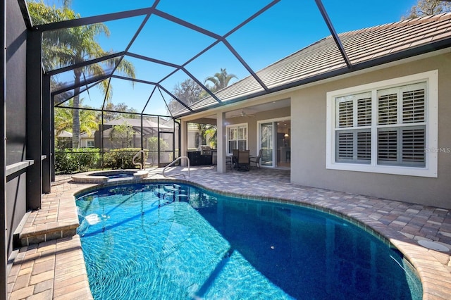 view of swimming pool featuring ceiling fan, a patio area, glass enclosure, and an in ground hot tub