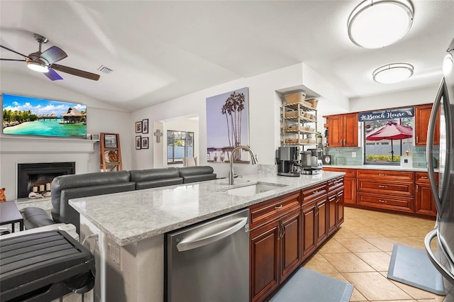 kitchen featuring sink, light tile patterned floors, stainless steel appliances, a center island with sink, and decorative backsplash