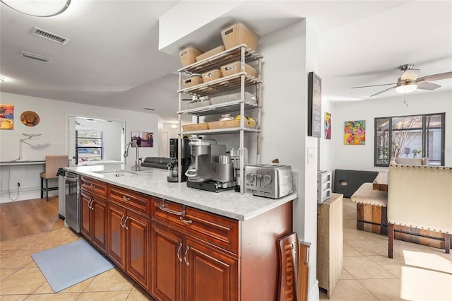 kitchen featuring light tile patterned floors, sink, dishwasher, ceiling fan, and light stone countertops