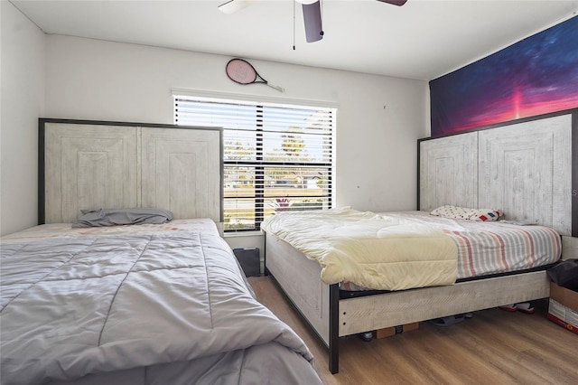 bedroom featuring ceiling fan, wood-type flooring, and multiple windows