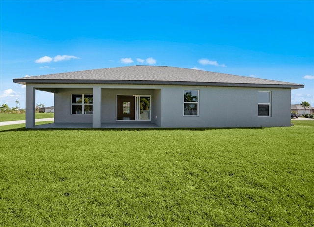 back of property with a patio and a lawn