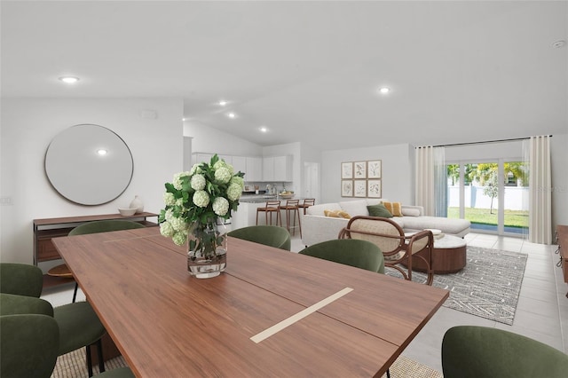 tiled dining space featuring lofted ceiling