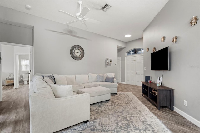 living room featuring hardwood / wood-style flooring, ceiling fan, and a textured ceiling