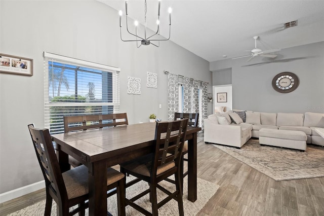 dining area featuring ceiling fan with notable chandelier and light hardwood / wood-style flooring