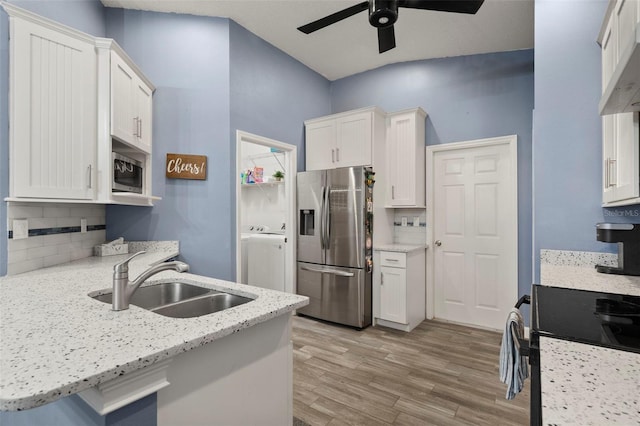 kitchen with sink, white cabinets, decorative backsplash, stainless steel appliances, and light wood-type flooring