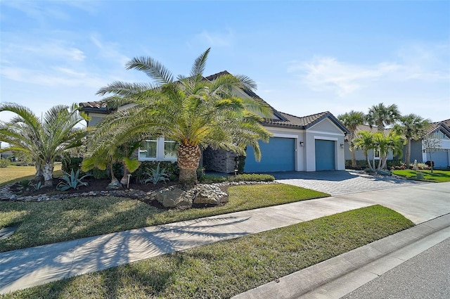 view of front facade featuring a garage, stucco siding, decorative driveway, and a tiled roof