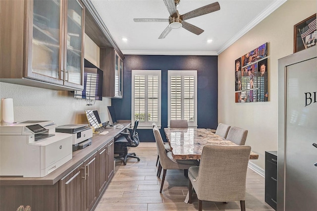 office space featuring baseboards, ceiling fan, light wood-style flooring, and crown molding