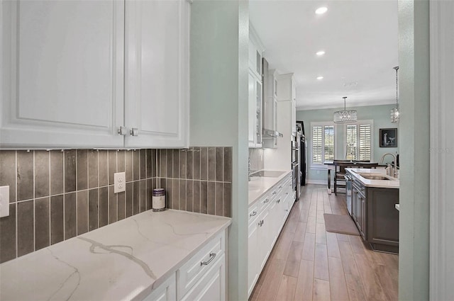 kitchen featuring decorative backsplash, a sink, and white cabinets