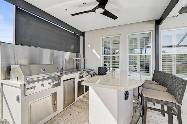 kitchen with high quality fridge, light countertops, a ceiling fan, and a center island