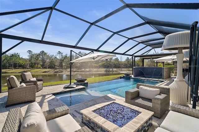 pool featuring glass enclosure, an in ground hot tub, a water view, a patio area, and an outdoor living space with a fire pit