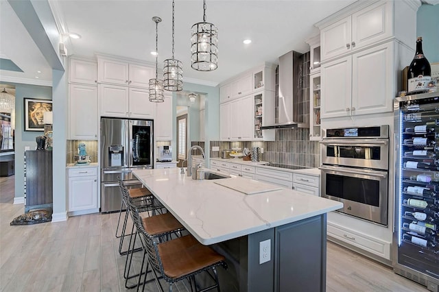 kitchen with crown molding, tasteful backsplash, appliances with stainless steel finishes, a sink, and wall chimney range hood