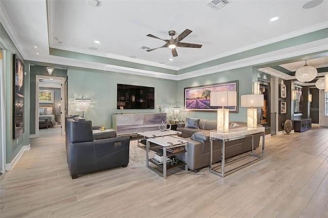 living area featuring a tray ceiling, wood finished floors, and visible vents