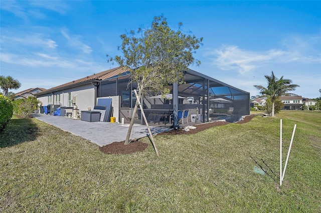 back of house featuring a lanai, a patio area, and a lawn