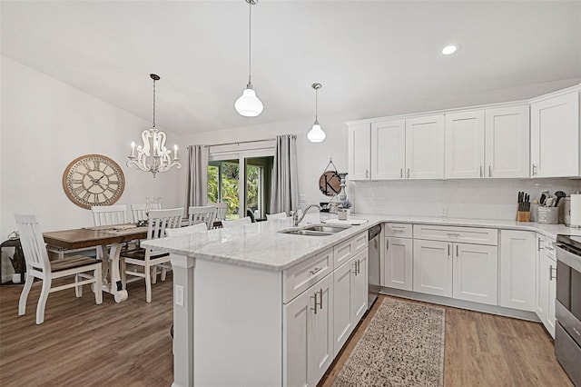 kitchen with sink, hanging light fixtures, white cabinets, and appliances with stainless steel finishes