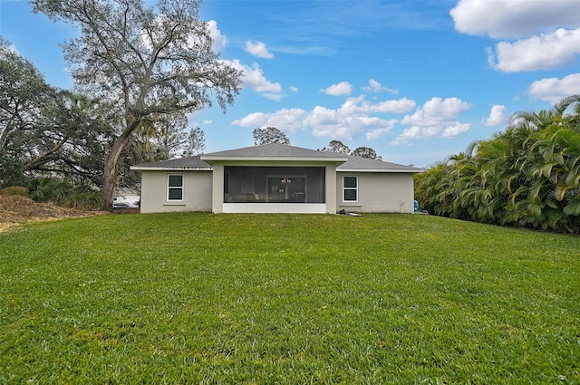 rear view of property featuring a sunroom and a lawn