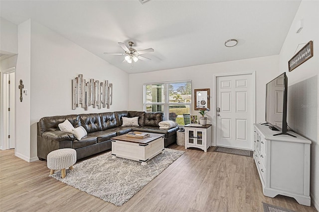 living room featuring ceiling fan, vaulted ceiling, and wood-type flooring