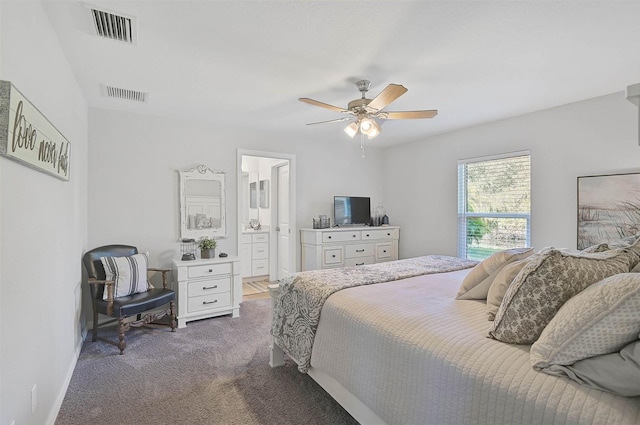 bedroom with connected bathroom, dark carpet, and ceiling fan