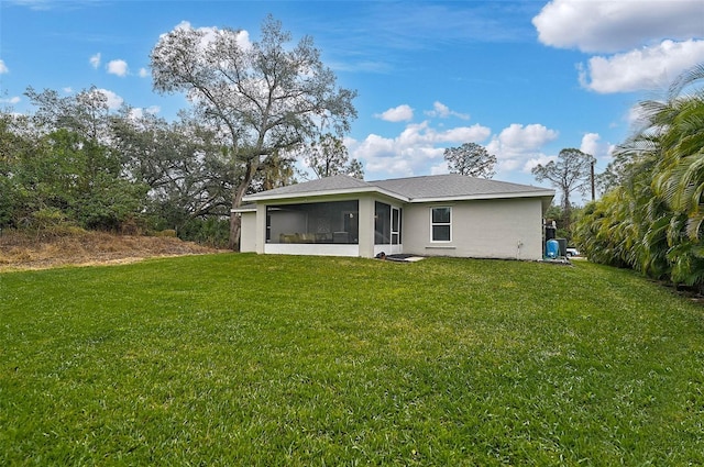 back of property with a lawn and a sunroom