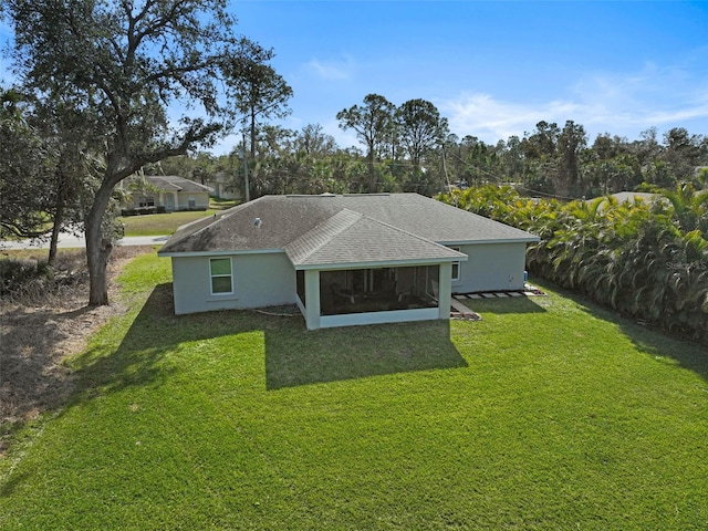 back of house featuring a sunroom and a lawn