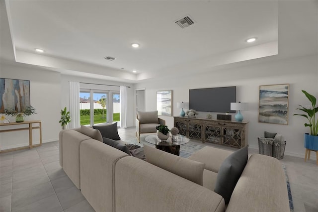 living room featuring light tile patterned flooring and a tray ceiling