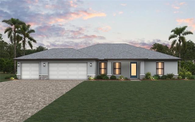 prairie-style home featuring a garage and a lawn