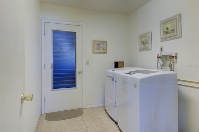 clothes washing area featuring washer and dryer and light tile patterned floors