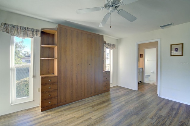 unfurnished bedroom featuring wood-type flooring, ensuite bathroom, and ceiling fan