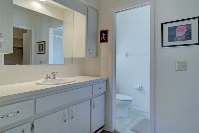 bathroom featuring vanity, backsplash, tile patterned floors, and toilet