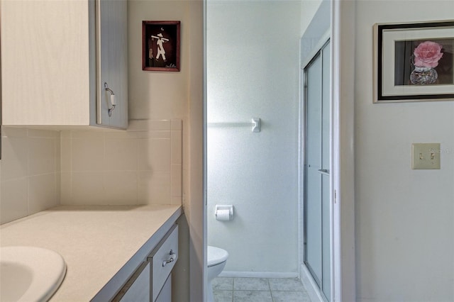 bathroom with tile patterned flooring, backsplash, vanity, toilet, and walk in shower