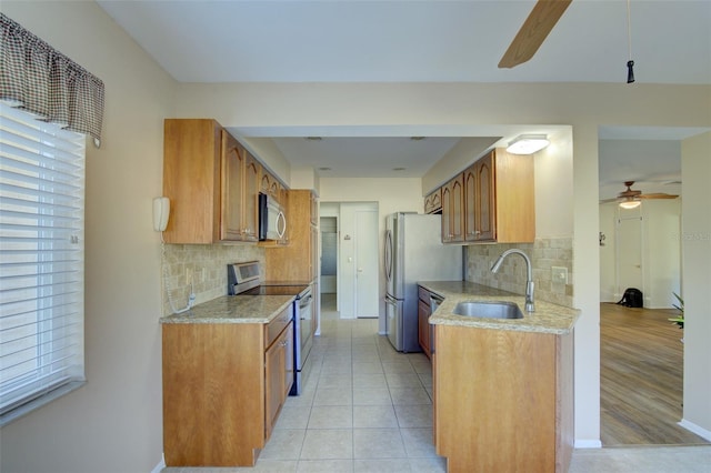 kitchen featuring sink, light tile patterned floors, ceiling fan, stainless steel appliances, and decorative backsplash