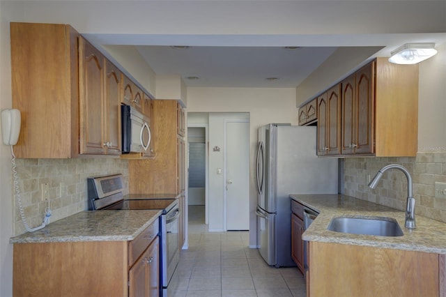 kitchen featuring sink, light tile patterned floors, stainless steel appliances, and decorative backsplash