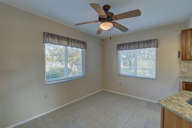 unfurnished dining area with light tile patterned floors and ceiling fan