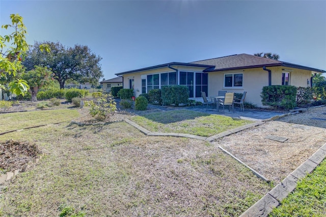 view of front of house with a sunroom, a front lawn, and a patio area