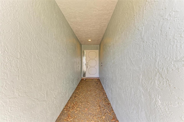 hall with a textured ceiling