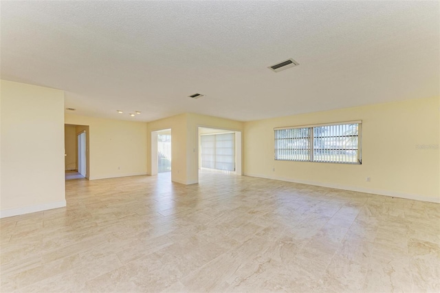 unfurnished room featuring a textured ceiling