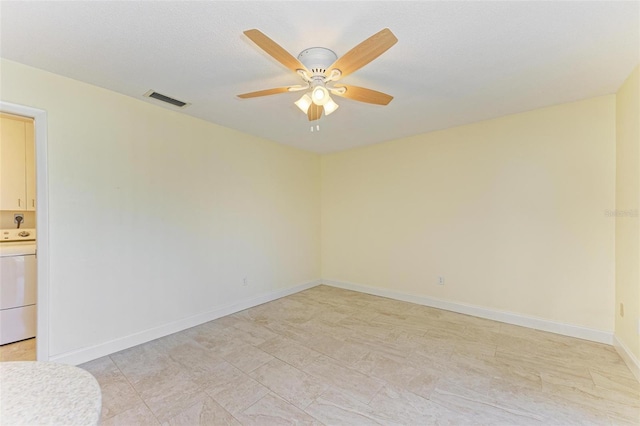 spare room featuring washer / clothes dryer and ceiling fan