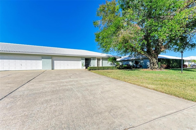 single story home featuring a garage and a front lawn