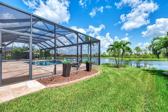 view of yard with a water view, glass enclosure, and a patio area