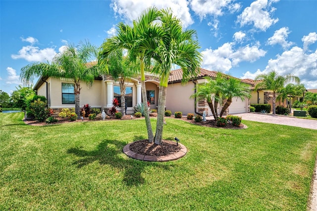 mediterranean / spanish home with a garage and a front yard