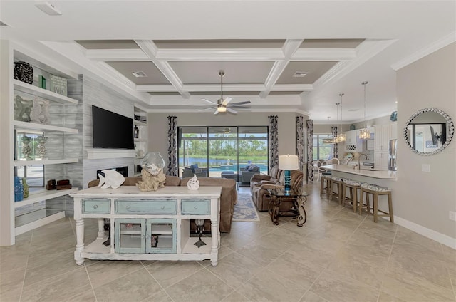 living room featuring ceiling fan with notable chandelier, sink, coffered ceiling, crown molding, and beam ceiling