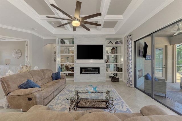 living room featuring a large fireplace, coffered ceiling, built in features, and ceiling fan