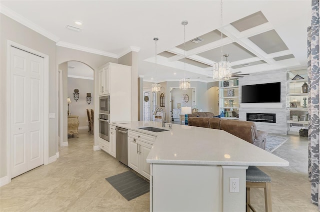 kitchen with a spacious island, sink, appliances with stainless steel finishes, pendant lighting, and white cabinets