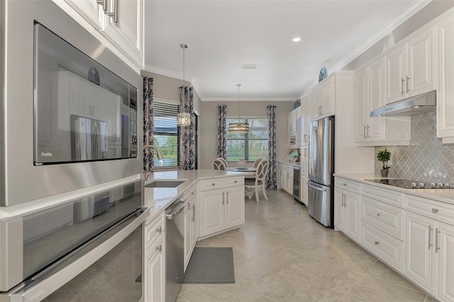 kitchen featuring pendant lighting, sink, ornamental molding, black appliances, and white cabinets