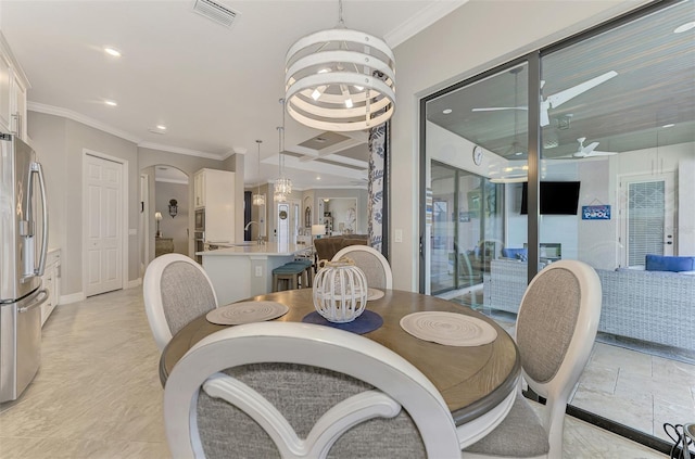 dining room featuring a notable chandelier, crown molding, and sink