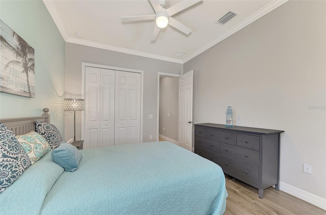 bedroom featuring crown molding, ceiling fan, a closet, and light wood-type flooring