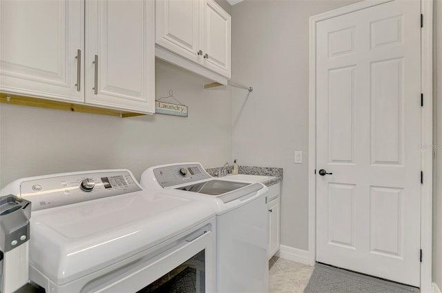 clothes washing area with light tile patterned flooring, cabinets, sink, and washer and dryer