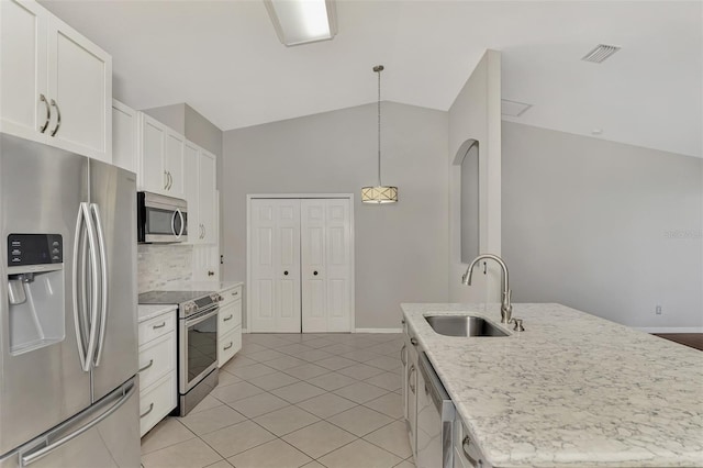 kitchen featuring sink, stainless steel appliances, white cabinets, and a center island with sink