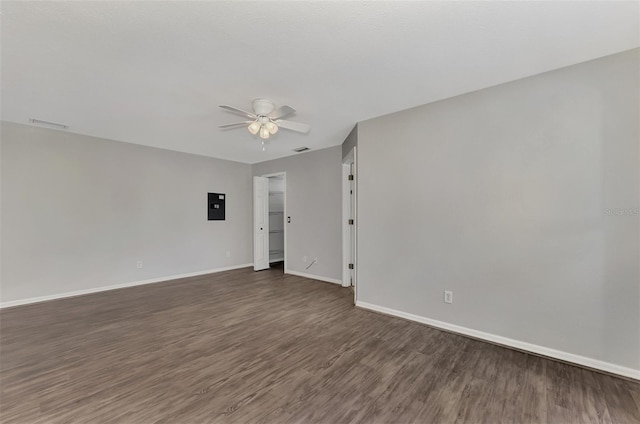 unfurnished room featuring electric panel, visible vents, baseboards, ceiling fan, and dark wood-type flooring