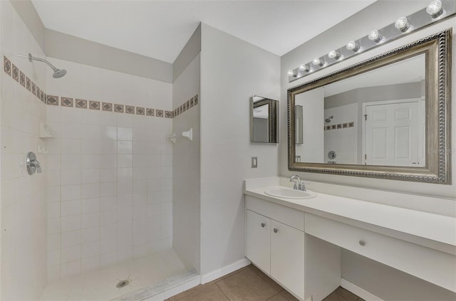 bathroom featuring vanity, tile patterned flooring, and a tile shower